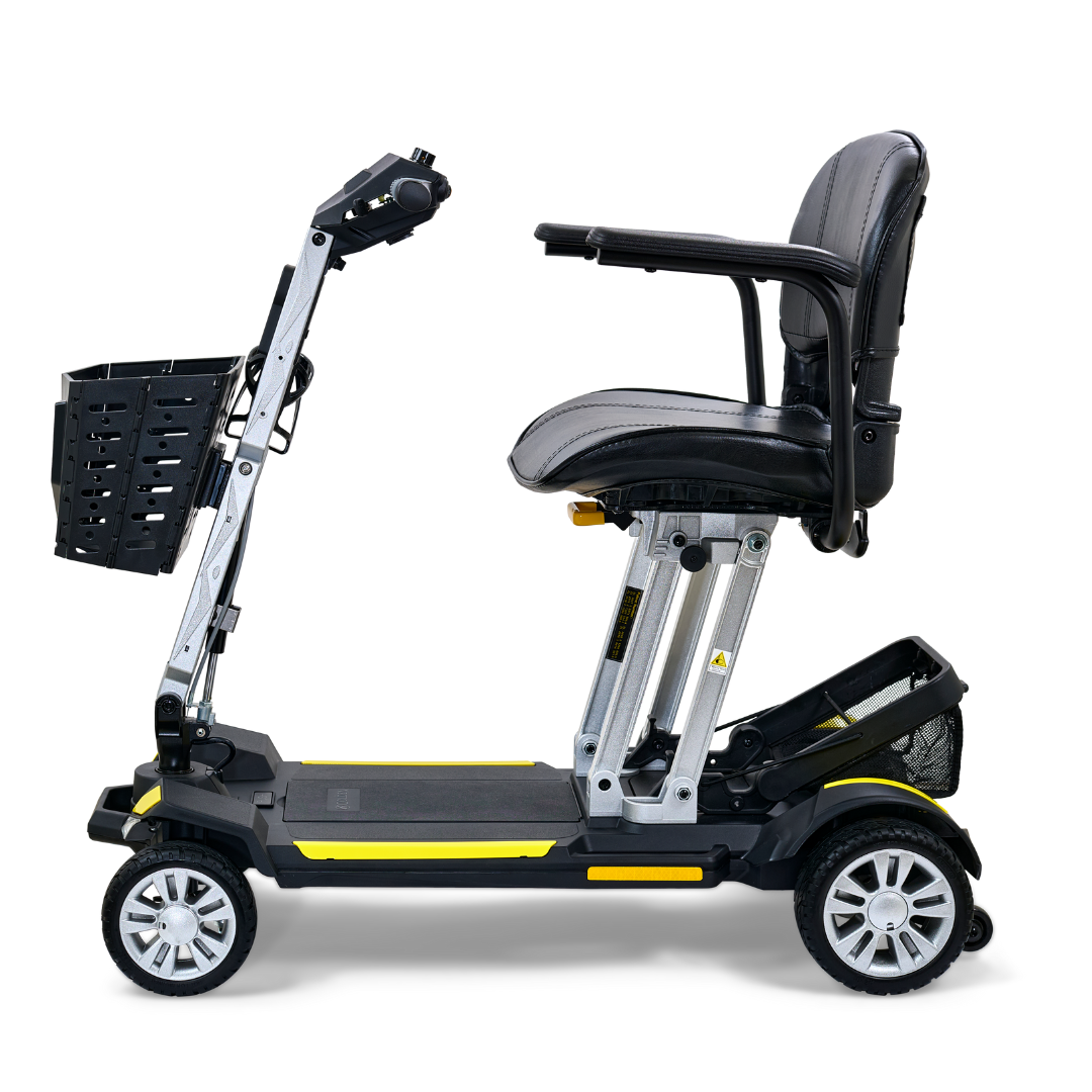 Introducing the Golden Technologies Portable Buzzaround GB120 Carry-On Travel Scooter: a compact and ultra-portable scooter featuring a fold-flat design with a comfortable black cushioned seat and a convenient small front basket. It boasts four wheels and a robust frame, engineered for effortless transportation and maneuverability, all driven by an efficient lithium-ion battery.