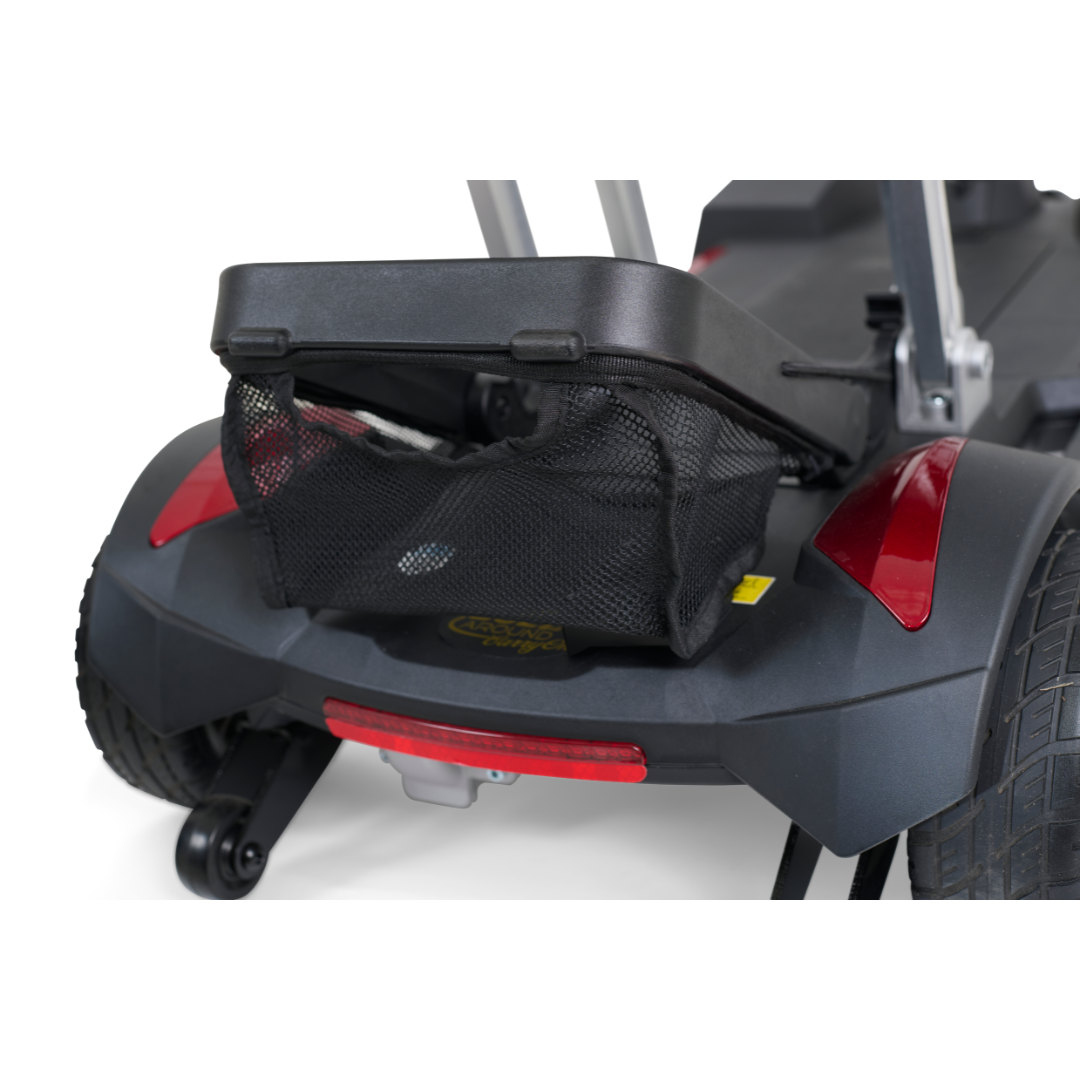 Close-up of the ultra-portable Golden Technologies Portable Buzzaround GB120 Carry-On Travel Scooter in black, featuring red accents and a mesh storage bag on the back. Large wheels ensure easy maneuverability over different terrains. The scooter, partially folded like a fold-flat trolley, showcases impressive compactness for convenience.