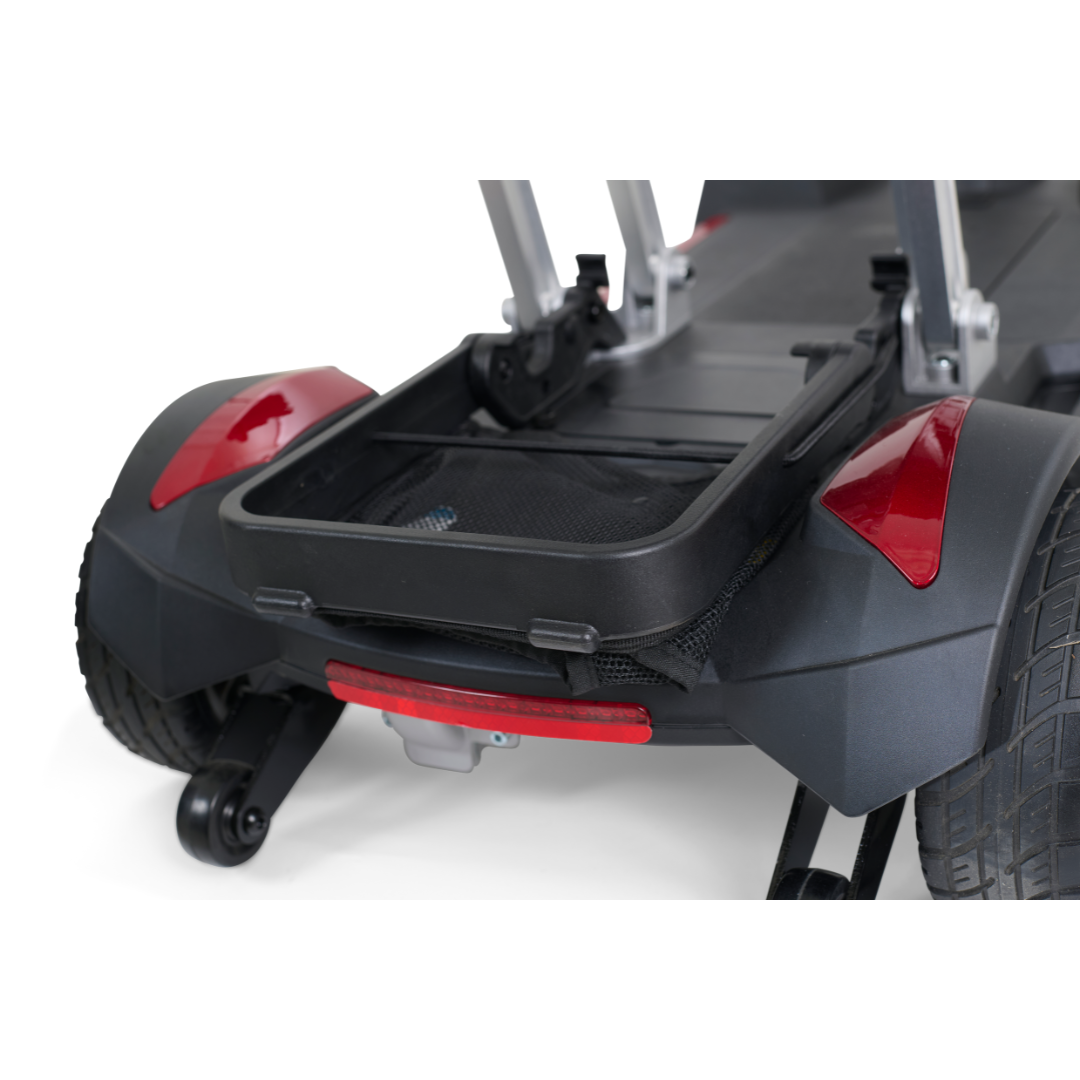Image showcasing the rear section of the Golden Technologies Portable Buzzaround GB120 Carry-On Travel Scooter, featuring two large wheels and a central open storage compartment. This fold-flat scooter sports a sleek black design with red accents, offering a sturdy and functional build. It comes equipped with an ultra-portable lithium-ion battery, ideal for easy travel.