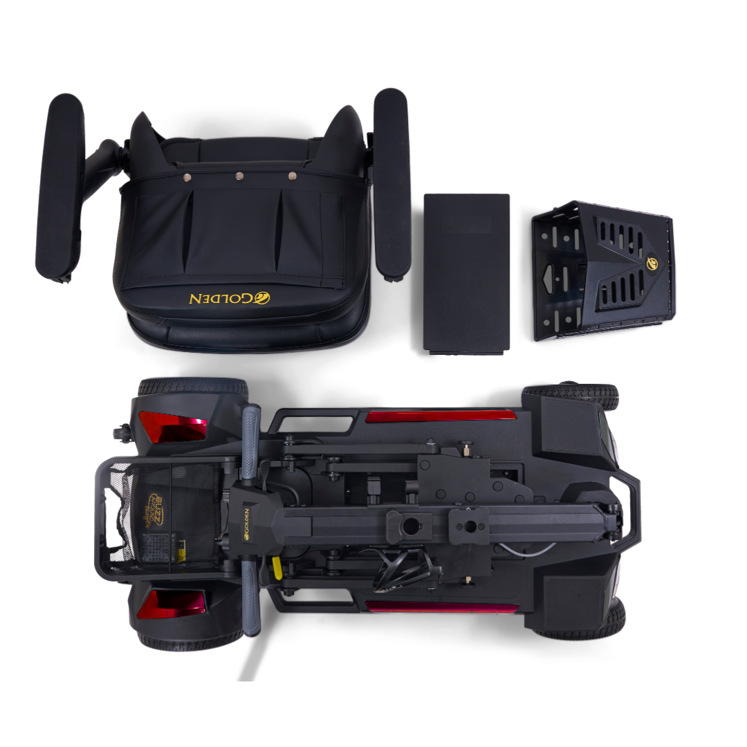Top-down view of the disassembled Golden Buzzaround GB220 CarryOn HD Travel Scooter, showing the seat, battery, rear wheel section, and chassis neatly arranged on a white background.