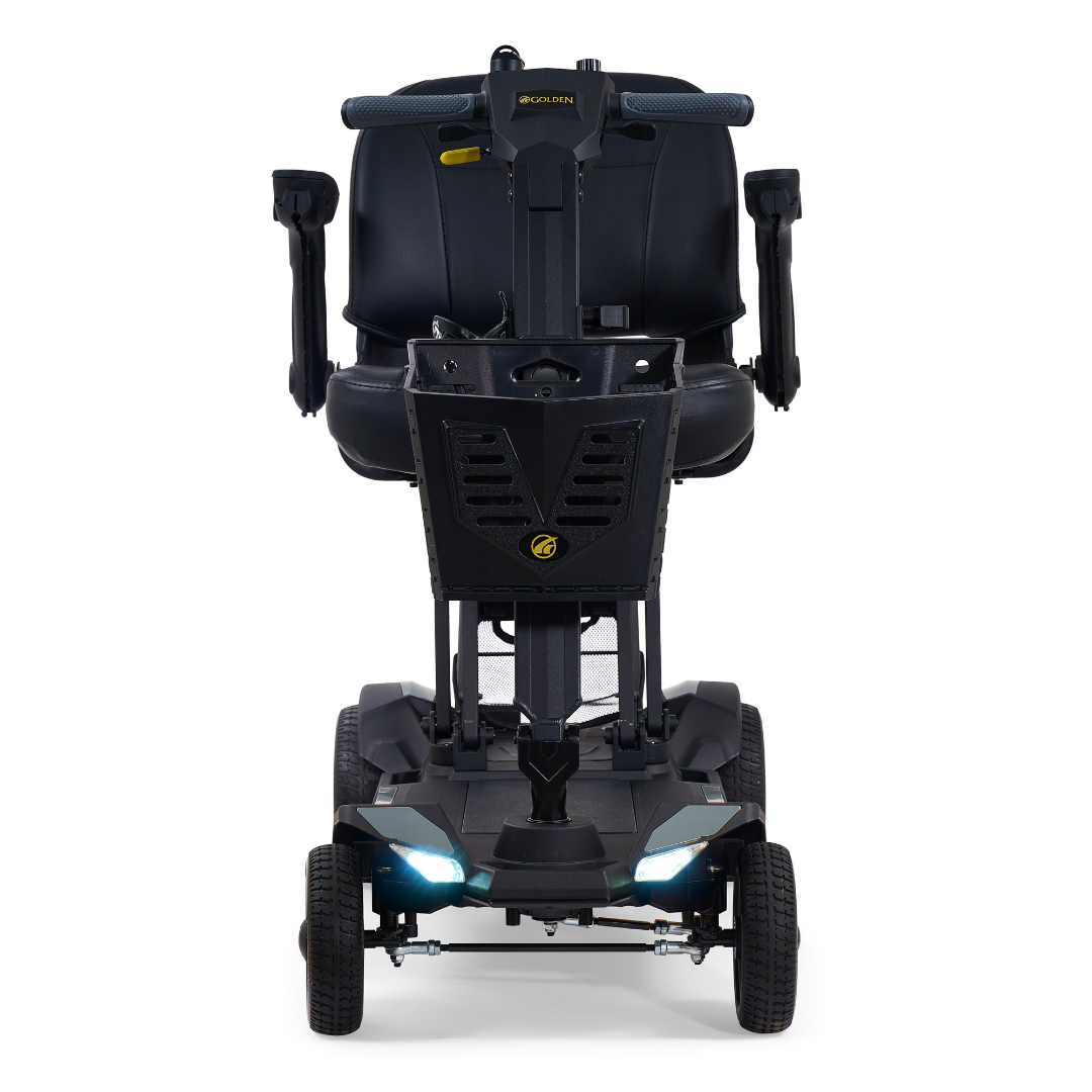 The Golden Buzzaround GB220 CarryOn HD Travel Scooter is a black, lightweight scooter with a front view showing the seat, armrests, handlebars, front wheels, and two bright headlights. Built for comfort and durability with a 400 lb. weight capacity.