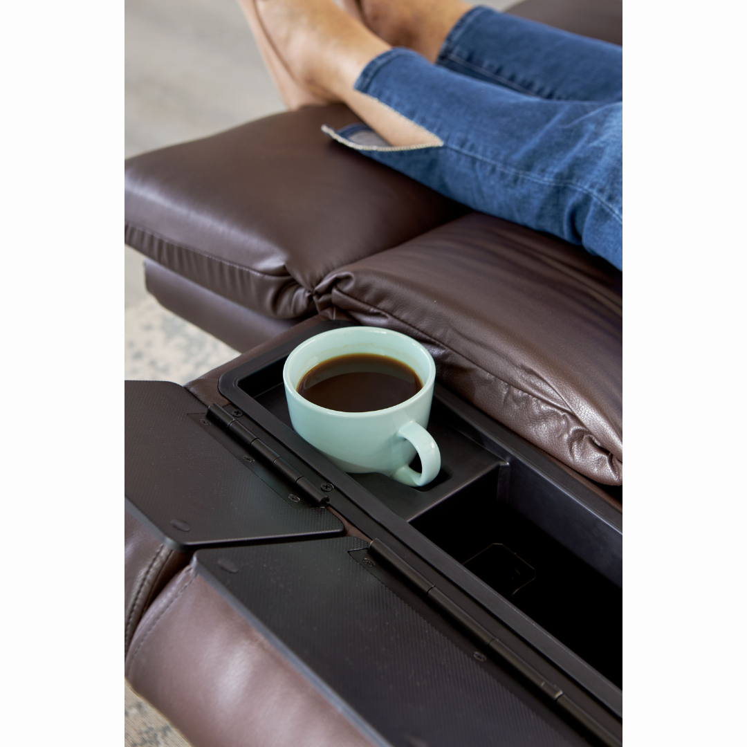 A person in blue jeans is relaxing on their Golden Cloud+ PR511 Recliner with Lift Assist - Medium Wide, feet up. A mint green coffee-filled mug rests on the adjoining tray of the 4-Zone Comfort Zone for ultimate relaxation.