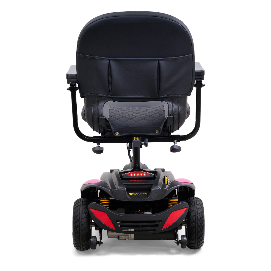 Rear view of the Golden Tech GB118 Buzzaround EX Portable Mobility Scooter with a black padded seat and backrest. This full-size scooter has four wheels, a sturdy frame, and control handles on each armrest for accessibility and comfort.
