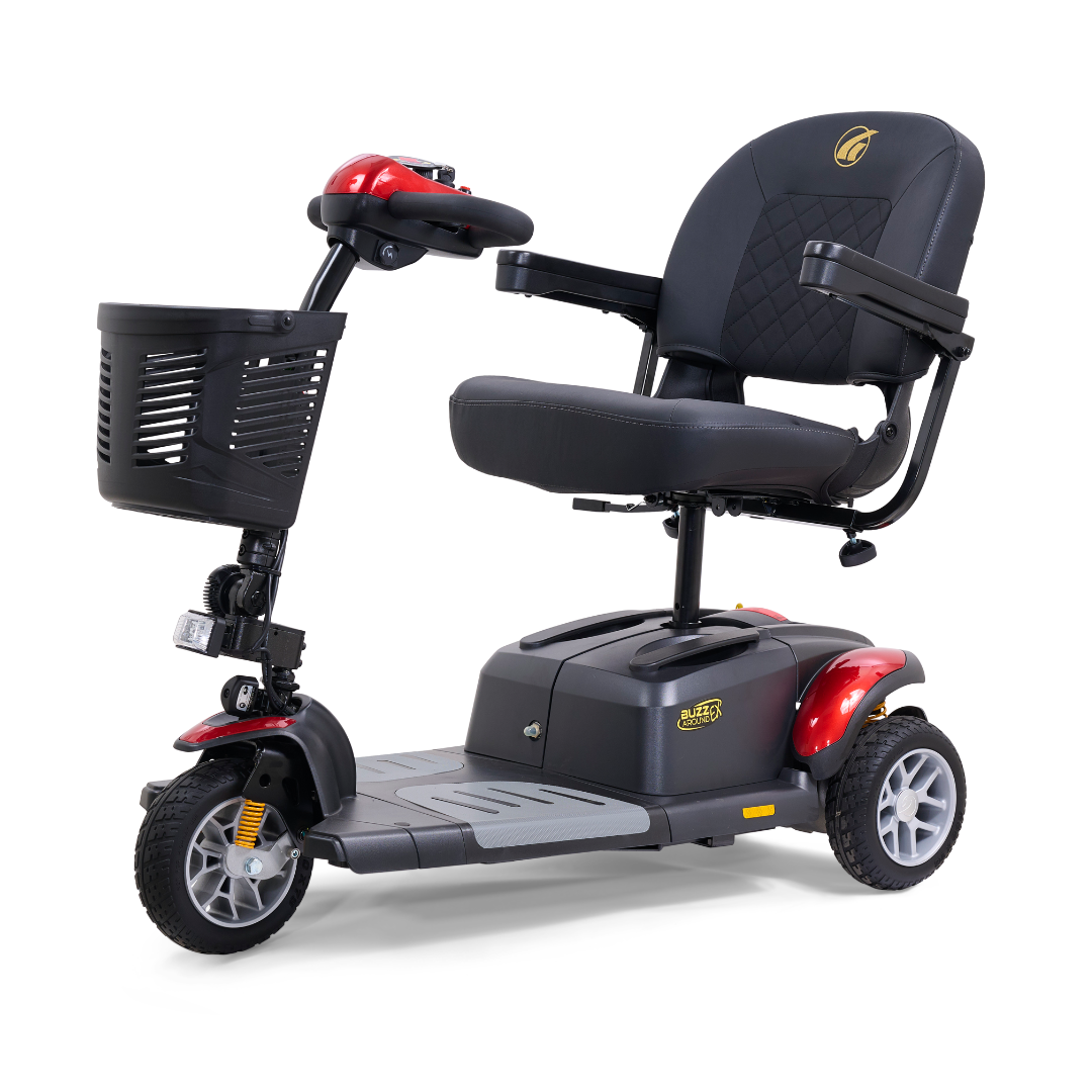 The Golden Tech GB118 Buzzaround EX is a three-wheeled scooter with a black seat, armrests, and a front basket. Its red and black design features a handlebar control panel and a front headlight for convenience.