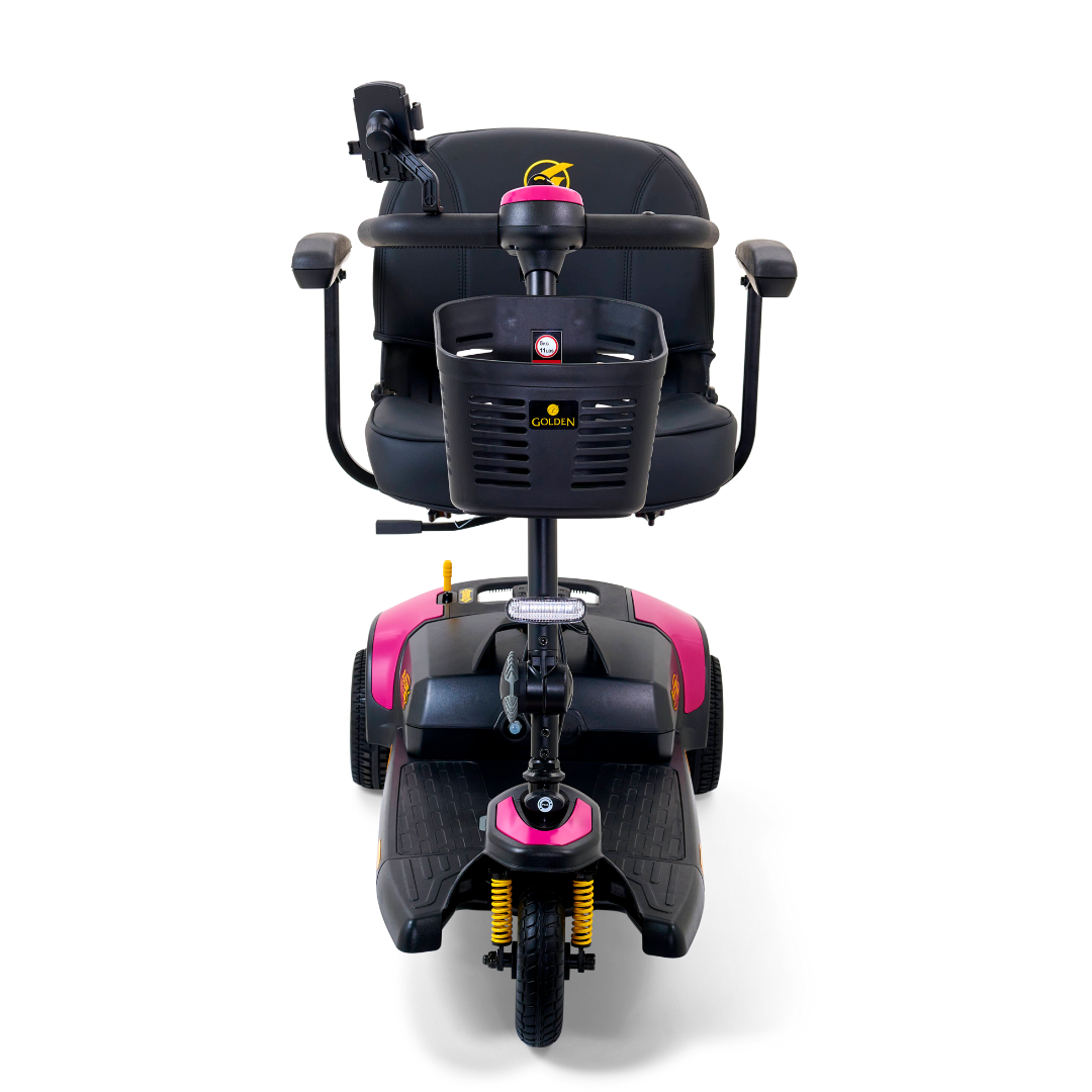 The Golden Tech GB121 Buzzaround XLS HD 3-Wheel Portable Scooter showcases a pink and black design with a stadium seat, armrests, handlebars, and front basket. It supports up to 325 lb., features Comfort Spring Suspension, and is designed for easy maneuverability.