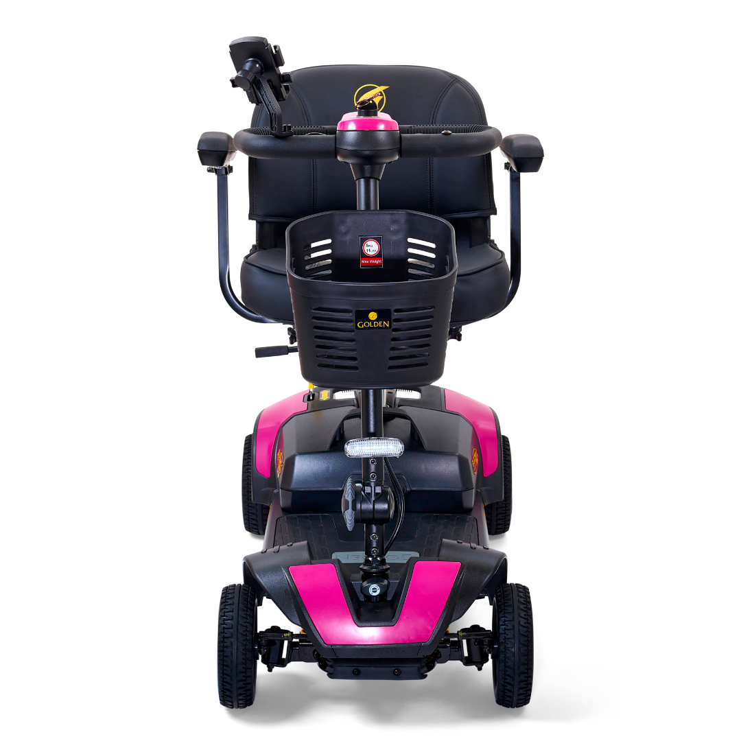 The Golden Tech GB124 Buzzaround XLS HD is a 4-wheel portable scooter with comfort spring suspension, black seat with pink accents, and handlebar controls. Its showcased from a frontal angle on a white background.