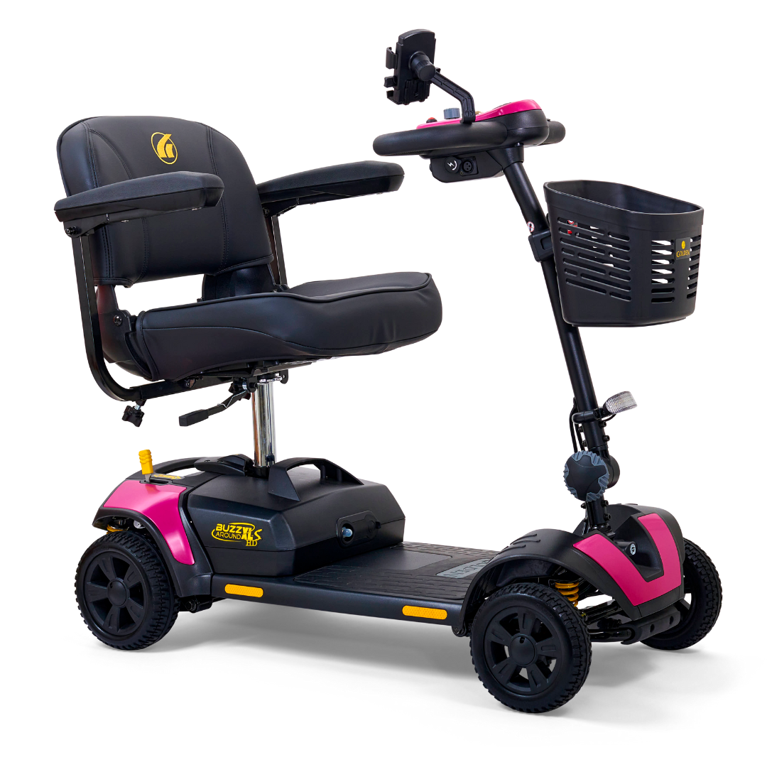 The Golden Tech GB124 Buzzaround XLS HD is a portable scooter with Comfort Spring Suspension. It features a black seat, armrests, pink accents, four wheels, handlebar controls, and a black basket for smooth indoor and outdoor rides.