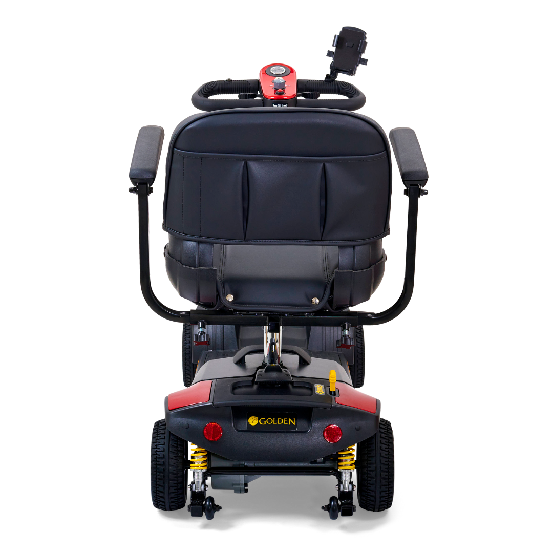 Rear view of the Golden Tech GB124 Buzzaround XLS HD scooter shows a cushioned seat, armrests, and small backrest. The Delta tiller control panel is visible. Featuring four wheels and a red/black design, it offers smooth rides with an XR Extended Range Battery.