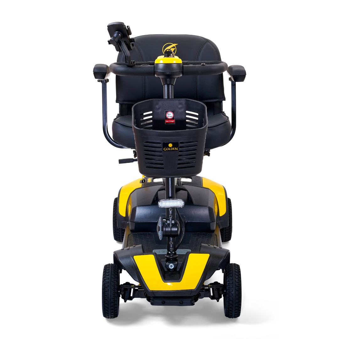 Front view of the Golden Tech GB124 Buzzaround XLS HD 4-Wheel Portable Scooter, showcasing a yellow and black design with a comfy seat and armrests. It features sturdy wheels, Comfort Spring Suspension for smooth rides, and an XR Extended Range Battery for longer journeys.