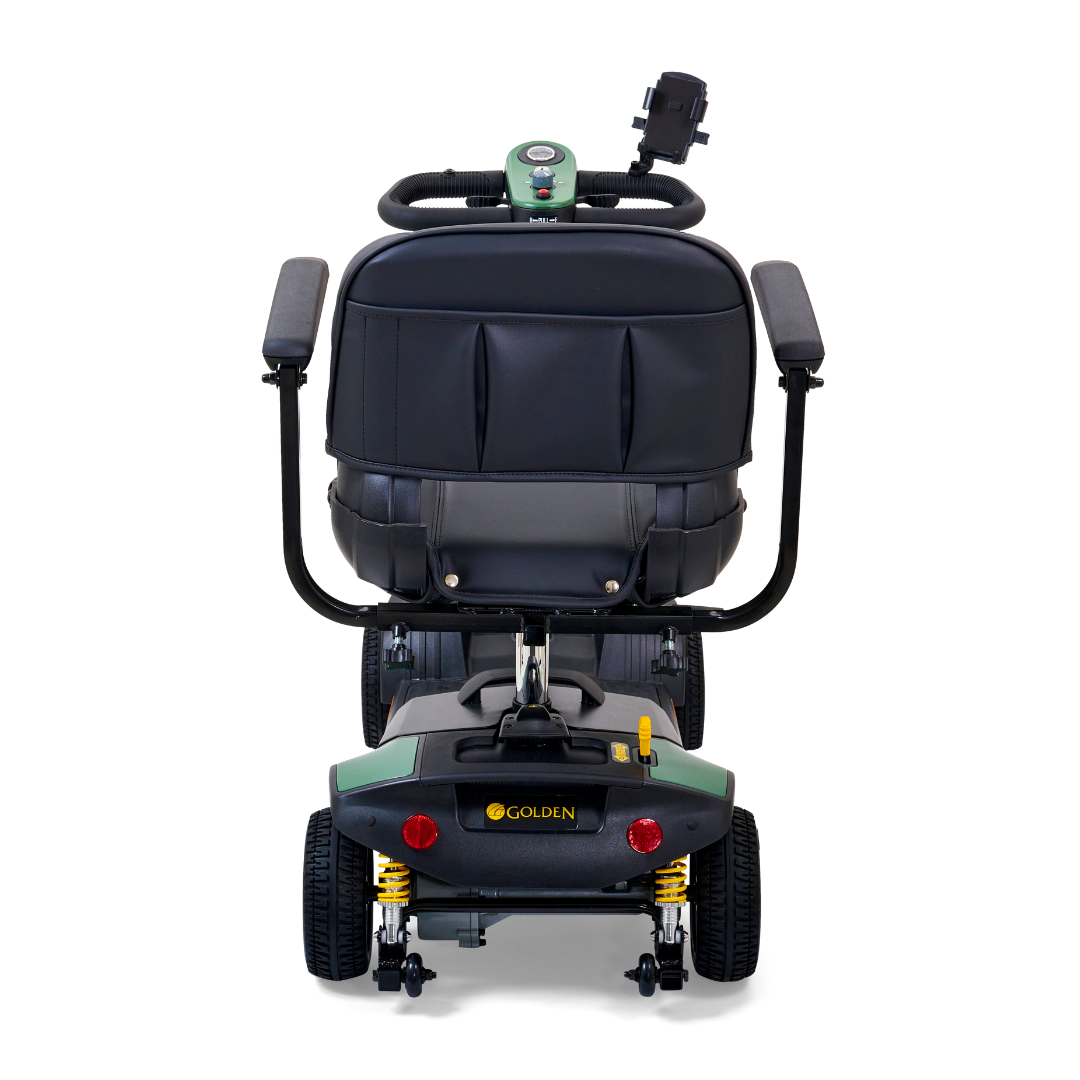 Rear view of a Golden Tech GB124 Buzzaround XLS HD, a green and black 4-wheel portable mobility scooter with a padded seat, two armrests, rear control panel, and Comfort Spring Suspension for smoother rides.