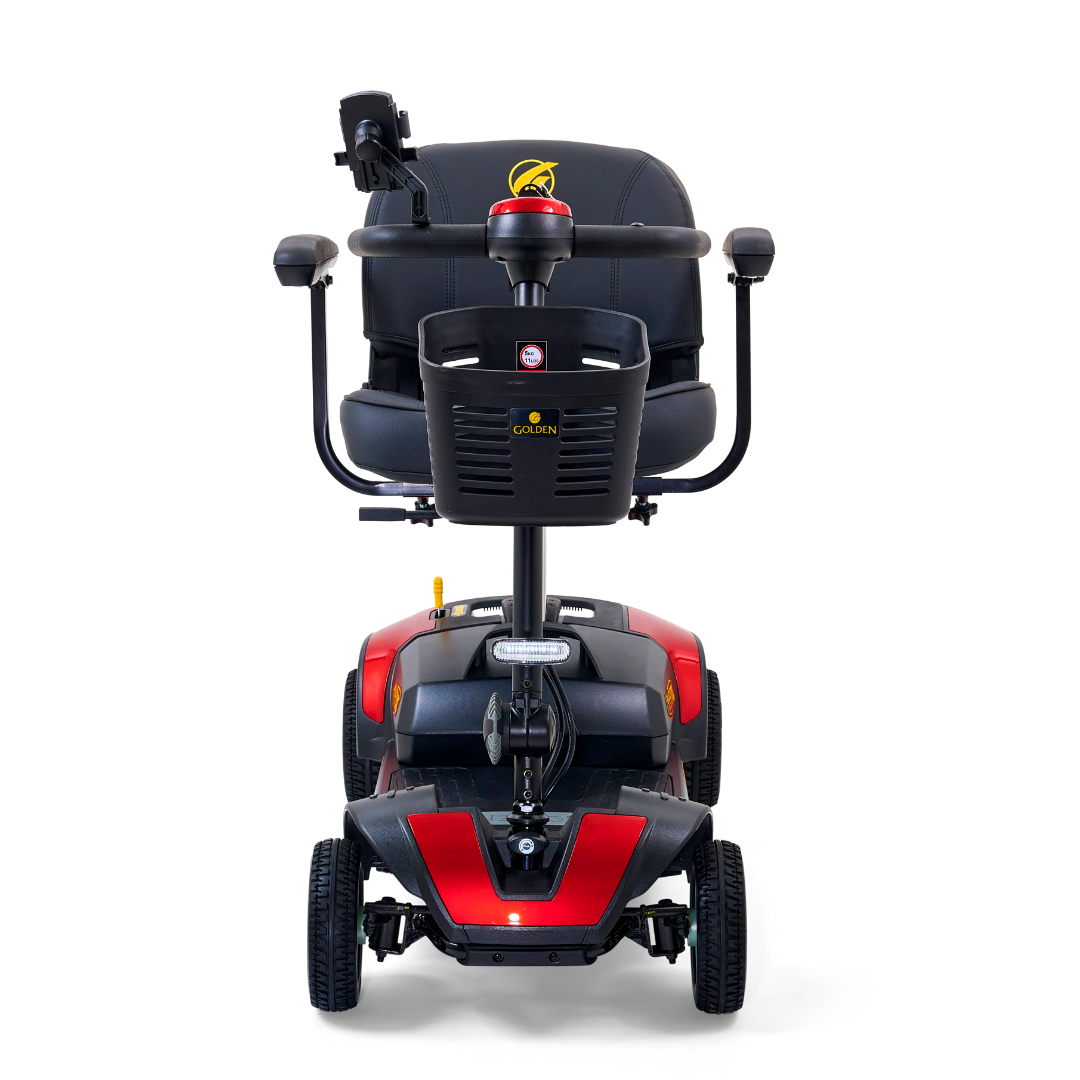 Front view of the Golden Tech GB124 Buzzaround XL 4-Wheel Portable Mobility Scooter in red and black. It has a captains seat, a control panel with handlebars, and offers enhanced maneuverability for easy navigation.