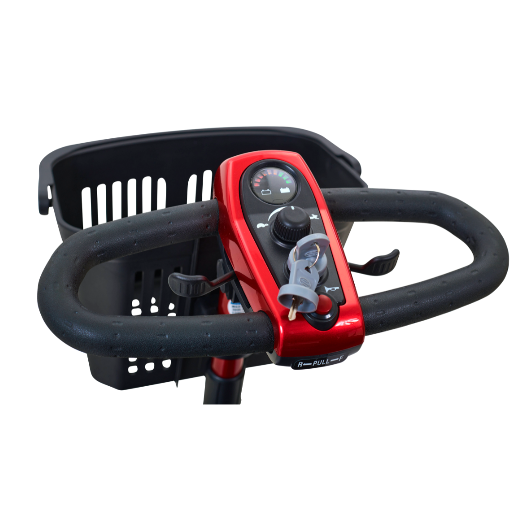 Close-up of a Golden Tech GL111 LiteRider 3-Wheel Mobility Scooters red handlebar with black textured grips, showcasing its Delta Tiller design with a central control panel, knob, display, and inserted keys. A black basket sits behind the handlebar.