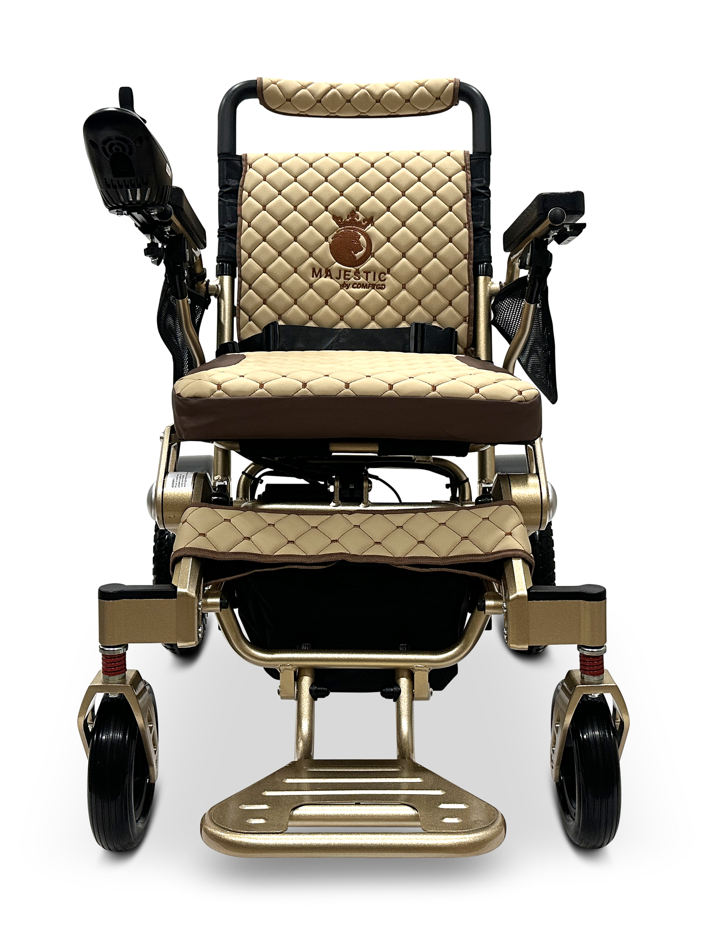 The MAJESTIC IQ-7000 Remote Controlled Electric Wheelchair is a luxurious model in beige and brown, featuring quilted upholstery, armrests, joystick control, and a footrest. The name "Majestic" is elegantly embroidered on the backrest and enhanced with sleek gold-tone accents. This lightweight folding wheelchair design ensures ease during travel.