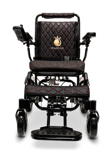 The ComfyGo MAJESTIC IQ-9000 Auto Reclining Electric Wheelchair features a black quilted seat and backrest with red stitching, aircraft-grade aluminum alloy frame, armrest controls, and a gold Majestic crown logo on the backrest.