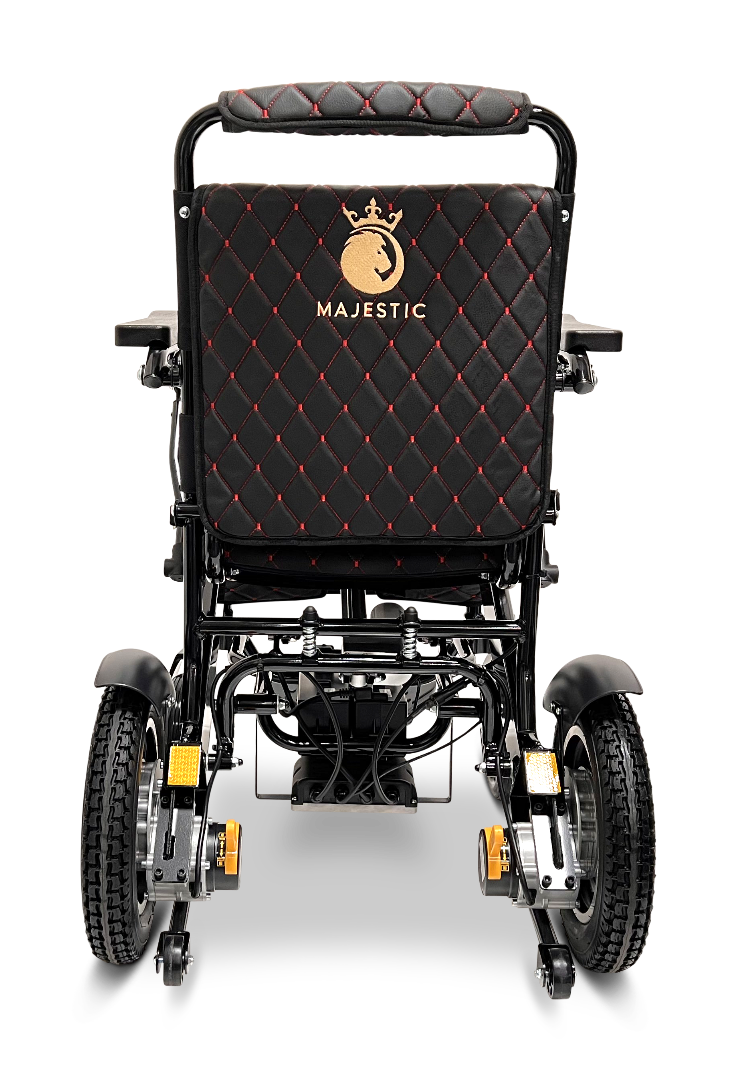 The ComfyGo MAJESTIC IQ-9000 Auto Reclining Electric Wheelchair is shown from the back, featuring black quilted upholstery with red stitching, a gold Majestic logo, and large rear wheels—all made with durable aircraft-grade aluminum alloy.
