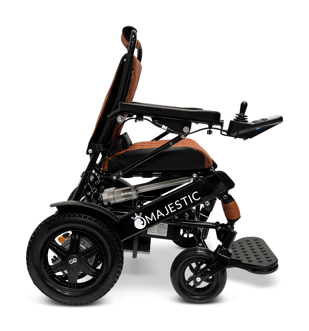 A side view of the ComfyGo MAJESTIC IQ-9000 Auto Reclining Electric Wheelchair in black and orange, featuring brushless silent motors, a digital joystick controller, large rear wheels, and a footrest.