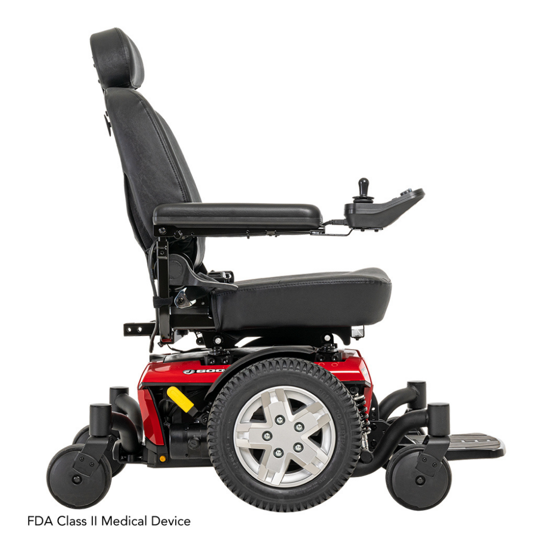 Side view of the Pride Mobility Jazzy® 600 ES Powerchair in black and red, featuring Mid-Wheel 6® technology, ATX Suspension, padded seat, joystick control on the right, large rear wheels, small front wheels. FDA Class II Medical Device shown below.