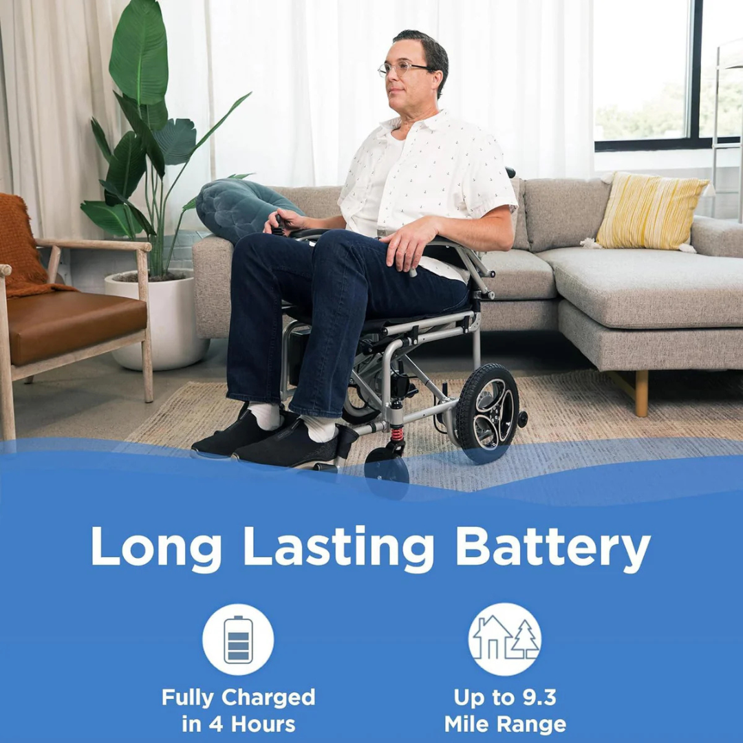 In a living room, a man sits in the Journey Air Elite Folding Carbon Fiber Powerchair, weighing just 29 lbs. The chair, ideal for travel, features a Long Lasting Battery, charges Fully in 4 Hours, and offers an Up to 9.3 Mile Range. A plant, sofa, and cushions complement the scene.