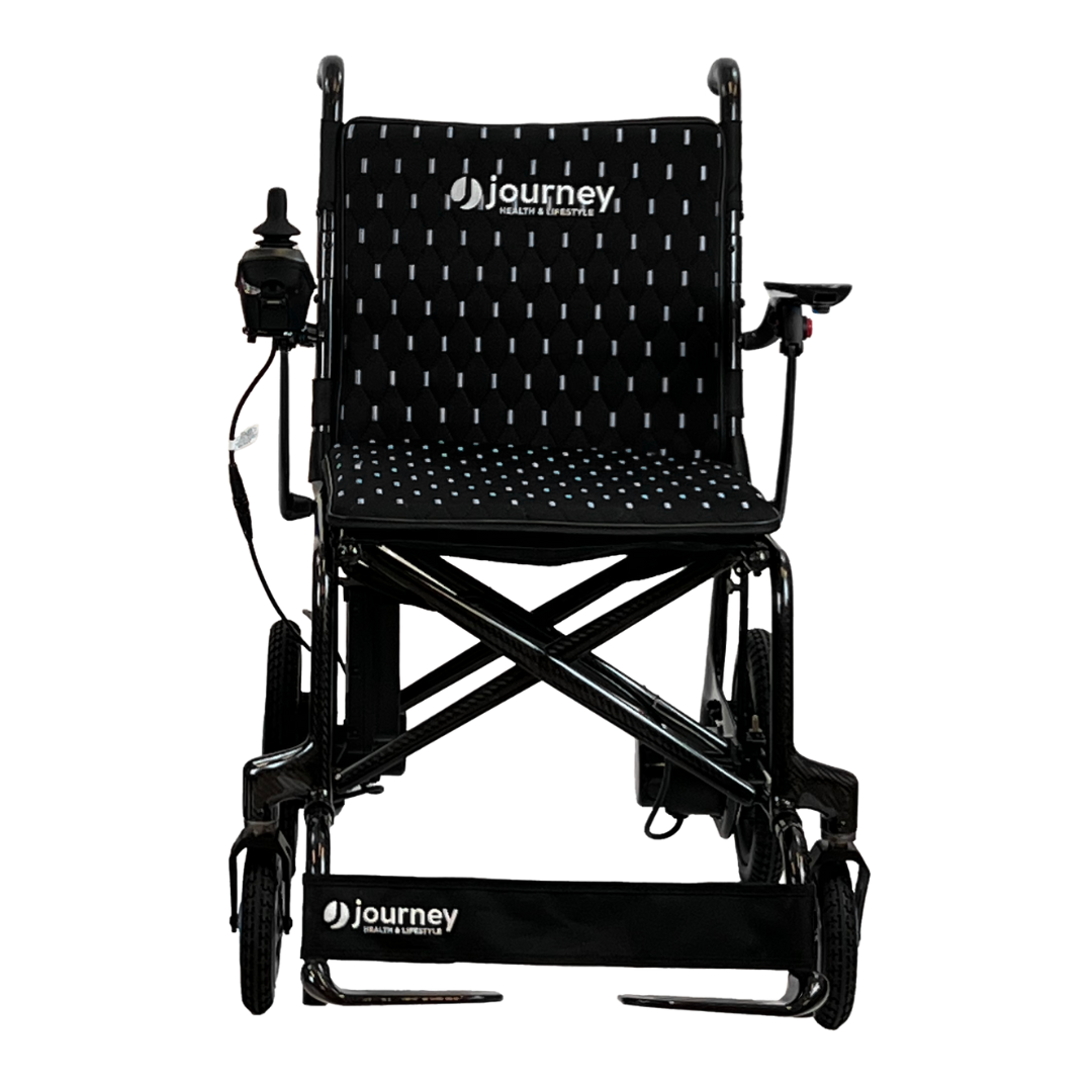 The Journey Air Elite Folding Carbon Fiber Powerchair weighs just 29 lbs and includes a joystick on the right armrest. It features a black design with white dotted seat and backrest, marked with journey on both the backrest and footrest, enhancing its travel-friendly appeal.