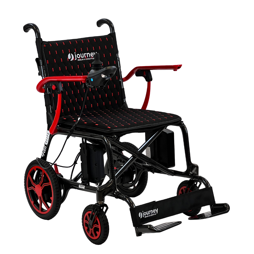 The Journey Air Elite Folding Carbon Fiber Powerchair, weighing only 29 lbs, is a lightweight motorized wheelchair featuring armrests, footrests, and joystick control. It has a sleek design with striking red and black accents. The brand Journey is displayed on the backrest and footrest.