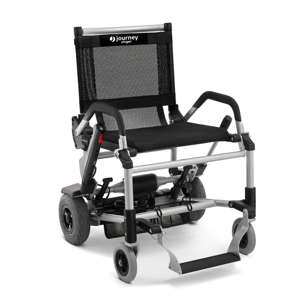 The Journey Zinger® Folding Powerchair, weighing only 47 lbs and FAA approved, features a sleek black and silver design with a mesh backrest, armrests, dual-lever steering, two large rear wheels, two small front caster wheels, and a footrest for easy maneuverability.