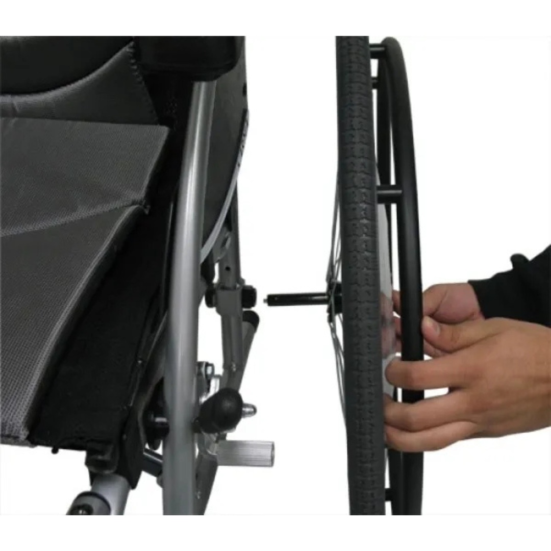 Hands skillfully adjust the wheel of a Karman S-Ergo 115 Ultra Lightweight Ergonomic Wheelchair, featuring a silver frame and black tire, to ensure optimal performance while highlighting its meticulously designed ergonomic seating system.