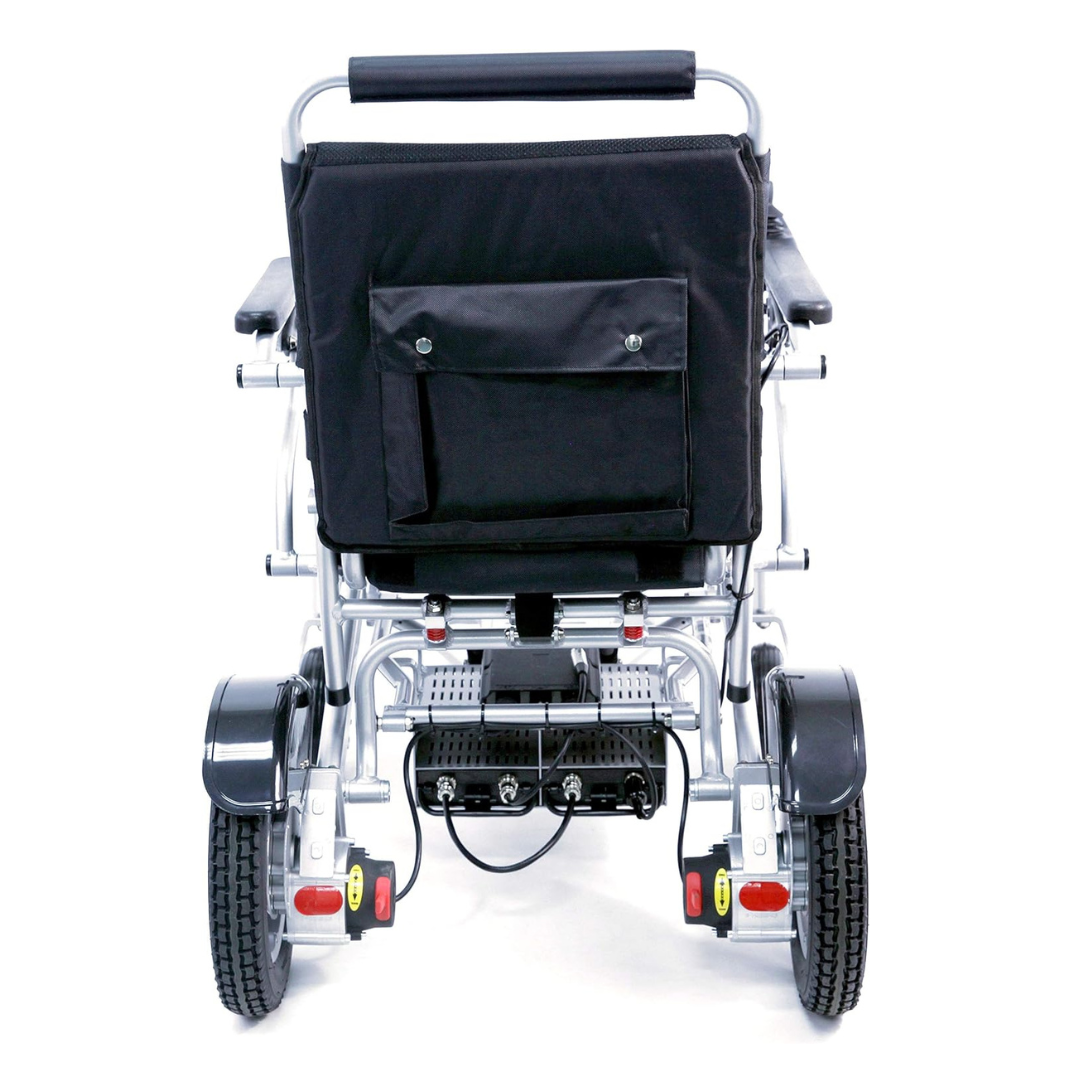 Rear view of the Karman Tranzit Foldable Lightweight Power Wheelchair in black, designed as a compact mobility device. It has large textured wheels, a padded handlebar, storage pocket on the backrest, and visible cables and electronics beneath the seat. FAA approved for air travel.