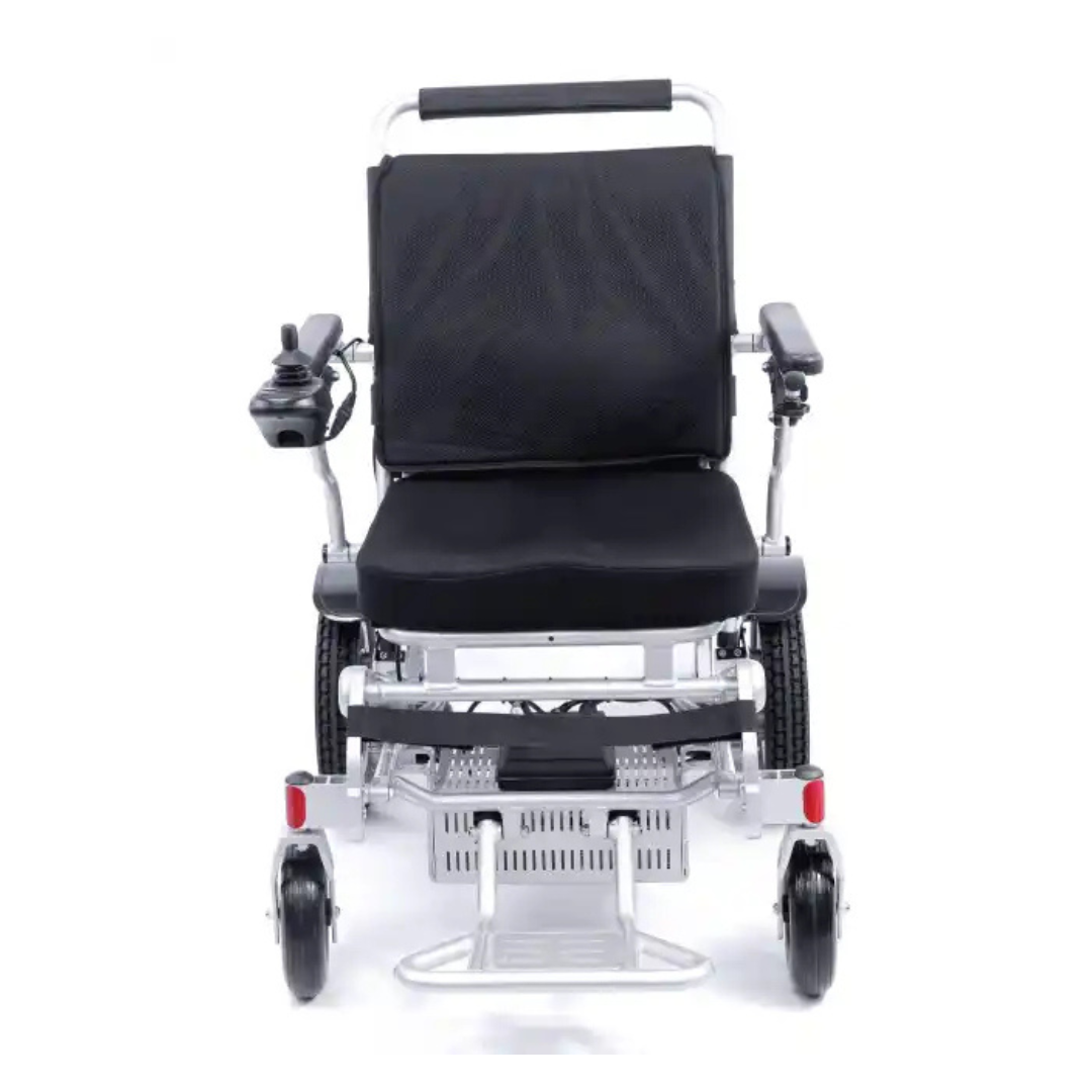 Front view of the Karman Tranzit Foldable Lightweight Power Wheelchair, FAA Approved, showcasing a sleek black and silver design with joystick control on the armrest, cushioned seat, footrest, smaller front wheels, and larger back wheels for smooth navigation.