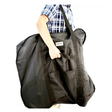 A person in a plaid shirt carries the Karman Travel Bag for Ergo Lite & Ergo Flight Wheelchairs. The structured black bag, labeled Karman, appears spacious—ideal for transporting your wheelchair on any journey.
