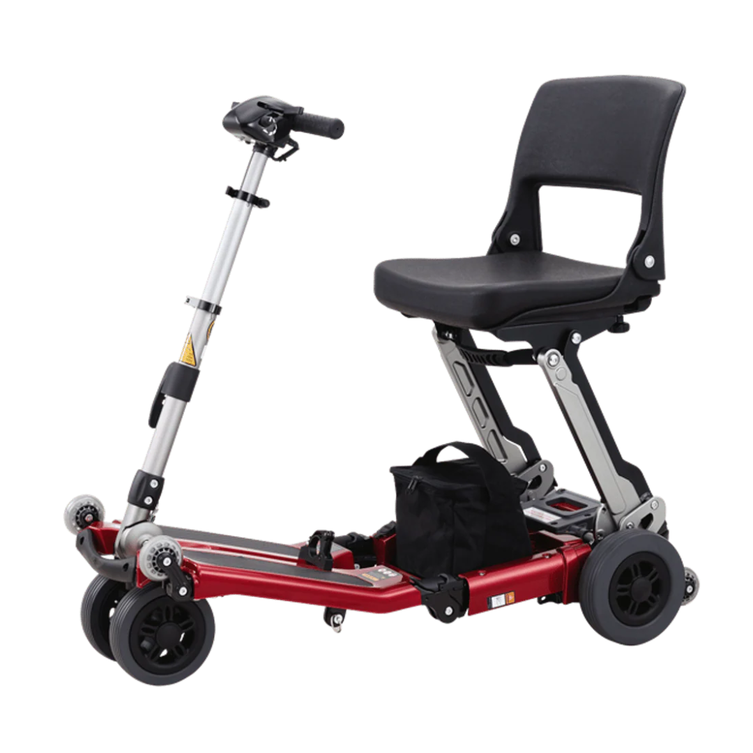 The FreeRider Luggie Classic II Travel Scooter is a compact, red, four-wheel, foldable mobility scooter with a black cushioned seat and backrest, handlebar steering, under-seat storage bag, and is airline-approved for easy travel.