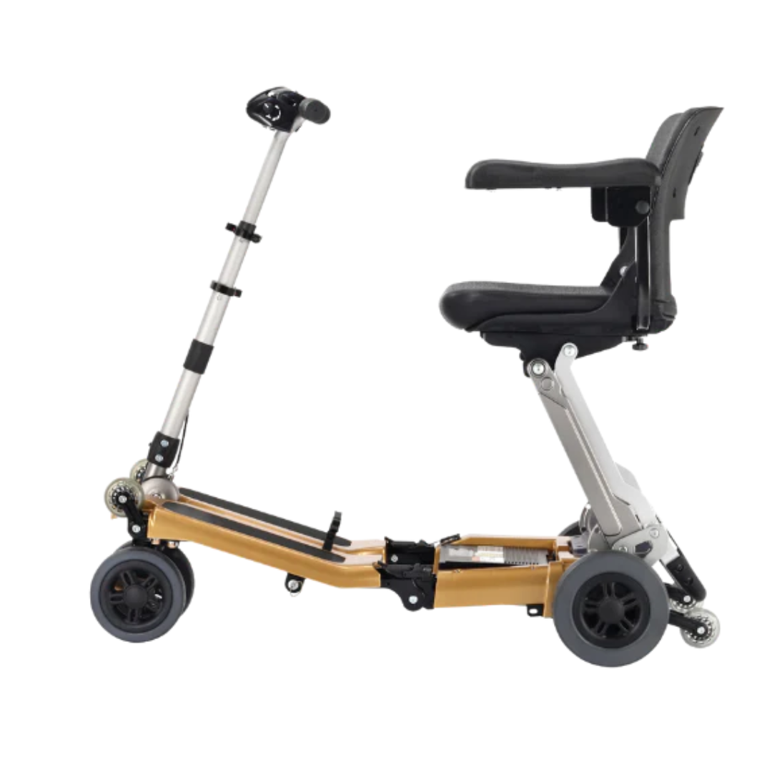 The FreeRider Luggie Golden Elite Travel Scooter is a compact, foldable mobility scooter with a gold frame, black seat, and three wheels. Airline approved and ideal for travel, it's shown from the side on a white background.
