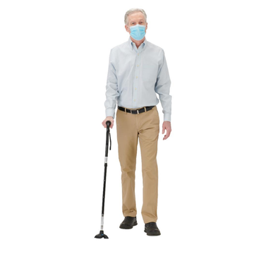 An older man in a face mask, light blue shirt, and khaki pants uses the Medline 4U 4-Point Offset Folding Free-Standing Hybrid Cane for mobility support against a white background.