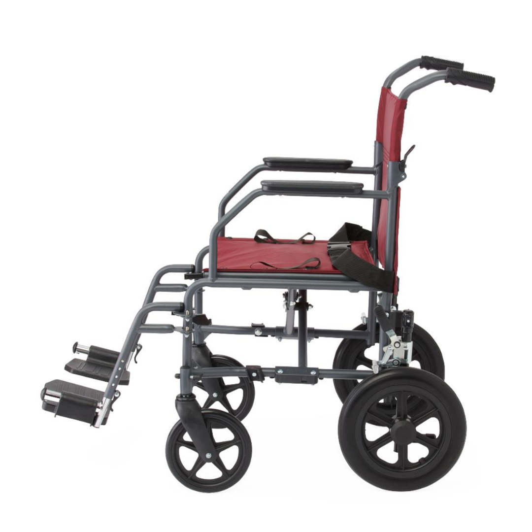 A side view of the Medline Designer High-Performance Transport Chair, featuring a lightweight, foldable gray steel frame, red seat and backrest, black armrests, large rear wheels, and elevated footrests.