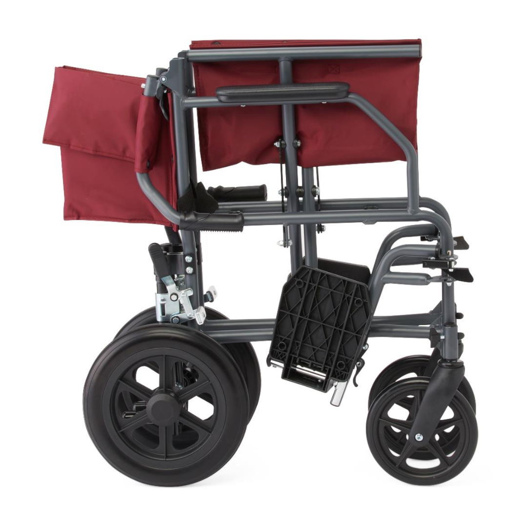 The Medline Designer High-Performance Transport Chair, shown folded from the side with a red seat and backrest, has a durable steel frame and large rear wheels for comfortable, lightweight mobility against a white background.