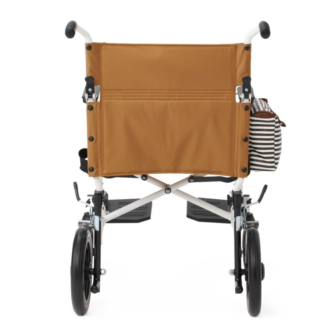 Rear view of a Medline Designer High-Performance Transport Chair with tan fabric backrest, black and white striped bag on one handle, footrests up, and a durable steel frame shown against a white background.