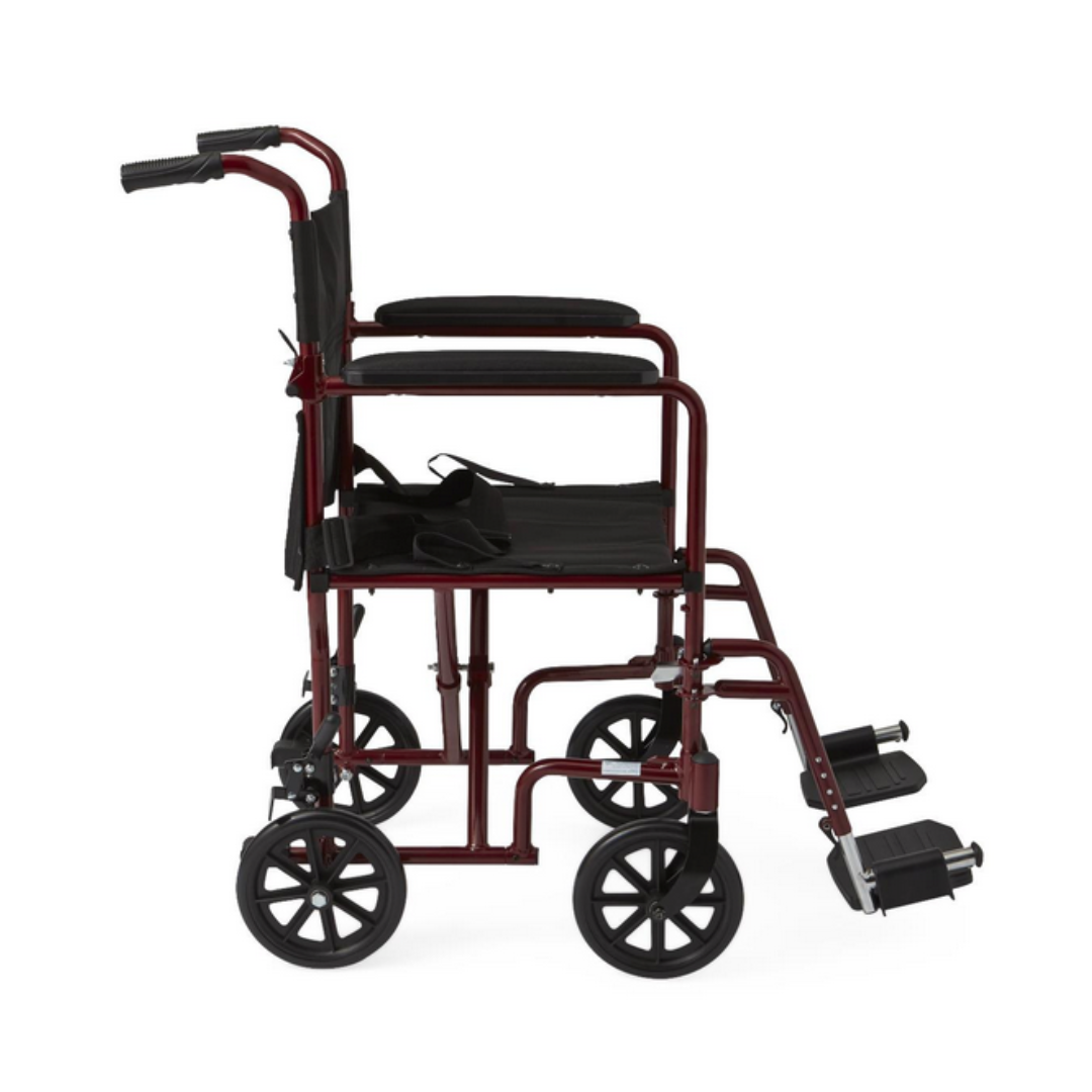 Side view of the Medline Basic Aluminum Transport Chair in red, featuring a black seat, full-length armrests, four wheels (two smaller at the front), footrests, and back handles for easy pushing. This lightweight and durable mobility aid enhances transport convenience.