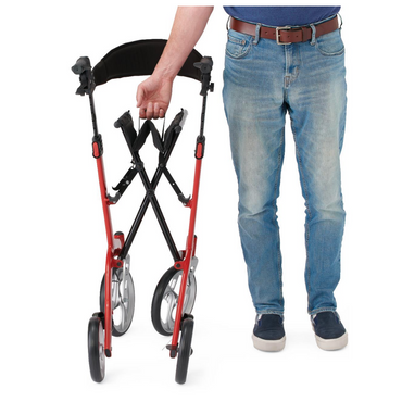 Dressed in a blue shirt, jeans, and navy shoes, a person showcases the Medline European-Style Aluminum Ultralite Rollator in red and black. With large wheels, this lightweight walker enhances mobility and is portable and easy to carry.