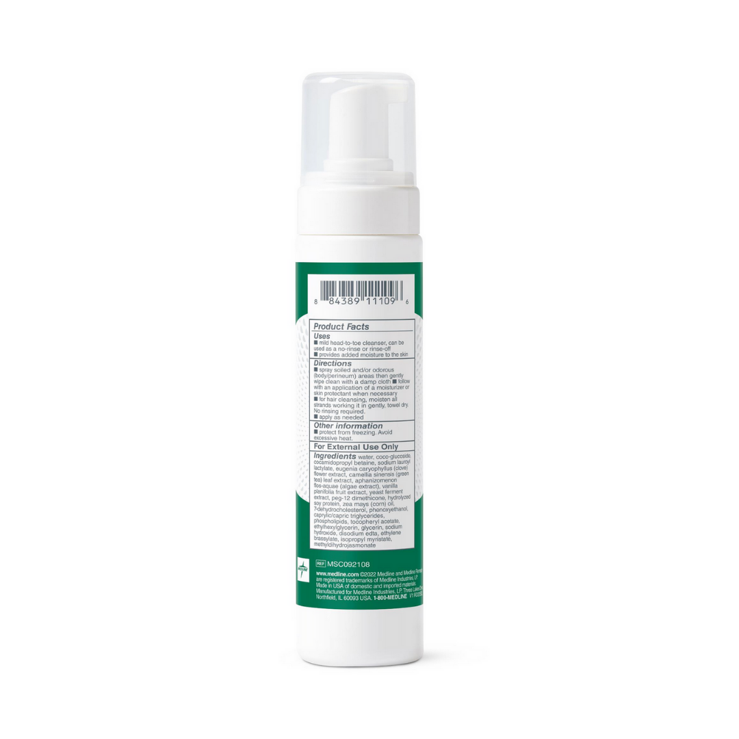 A rear view of a white bottle with a pump and green label, showing product info, instructions, warnings, and barcode for Medline Remedy Clinical No-Rinse Foam Cleanser - Body Wash & Shampoo.