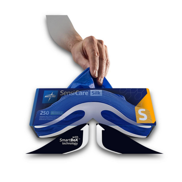 A hand pulls a blue Medline SensiCare Silk Nitrile Exam Glove with SmartBoX Design from a box marked chemotherapy-rated, containing 250 size S gloves, with one glove partially dispensed from the top.