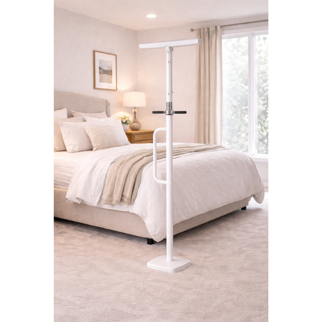 A Medline Security Pole with Handle - Fall Prevention Standing Aid, in white and free-standing, is placed by a bed in a bright bedroom with large windows, beige carpet, and light bedding for support and safety.