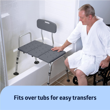 A man in a white robe smiles while sitting in a wheelchair and touching the Medline Tub Transfer Bench with a rust-resistant aluminum frame, which fits over tubs for easy transfers.