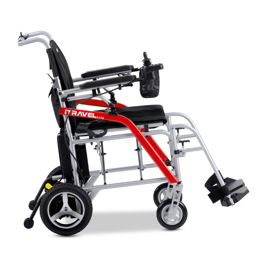 Side view of the Metro Mobility iTravel Lite Portable Powerchair—a modern, lightweight, airplane-friendly electric wheelchair with a red and silver frame, black seat, padded armrests, footrests, and a compact control panel for easy travel.