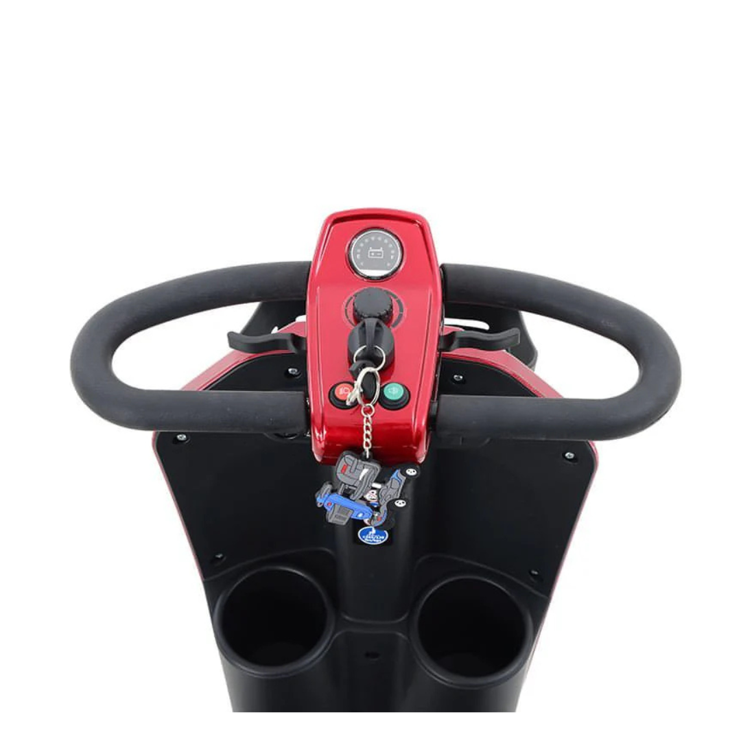 Top-down view of the Metro Mobility MAX Plus Scooter’s red handlebar, showing a control panel, two keys in the ignition, and two cup holders. This model features a powerful 300W motor for reliable performance.