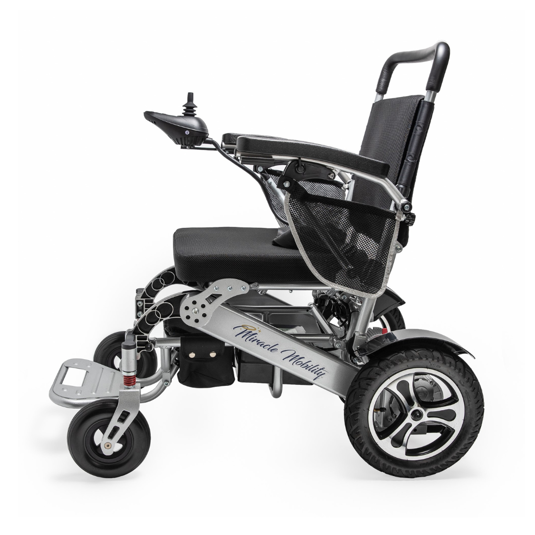 Side view of the Miracle Mobility Platinum 8000 Portable Powerchair - Open Box, featuring a black seat, silver frame, joystick on the armrest, mesh side pocket, and large rear wheels—perfect as a travel-friendly wheelchair. Brand logo shown on frame.