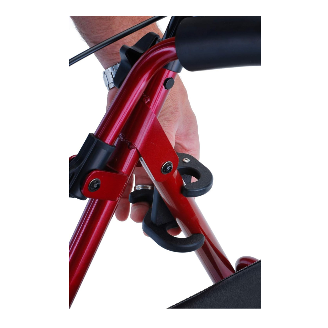 A close-up shows a person’s hand adjusting the black latch of the NOVA Medical Cane Holder, which is attached to a red metal frame of a rollator or folding walker.
