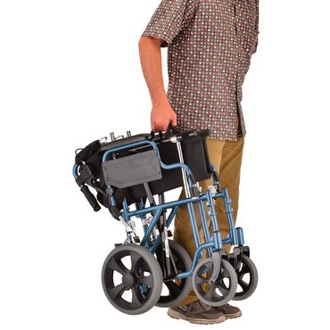 A person carries the Nova Medical 352 Lightweight Transport Chair with Locking Hand Brakes and XL Wheels by its frame, showcasing its portability and compact design.