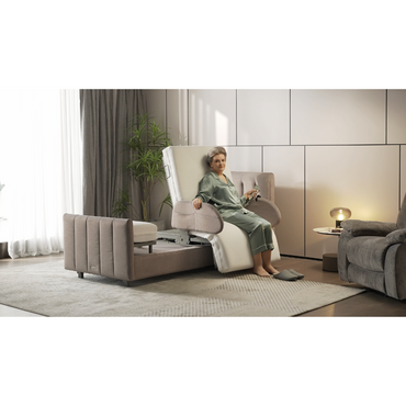 An elderly person enjoys the comfort of a Charme Starsleep Orin bed with heat and massage. The multifunctional room includes a small table, lamp, plant, and sheer curtained windows. Paneled walls and soft carpet complete the serene setting.