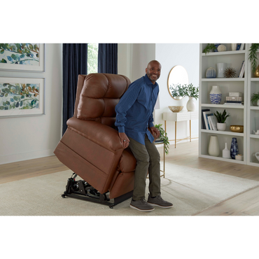 A smiling man rises from a Golden Tech PR515 Cloud Recliner With Lift Assist, ZG+ & Twilight in a bright, modern living room featuring decorative shelves, framed art, and plants in the background.