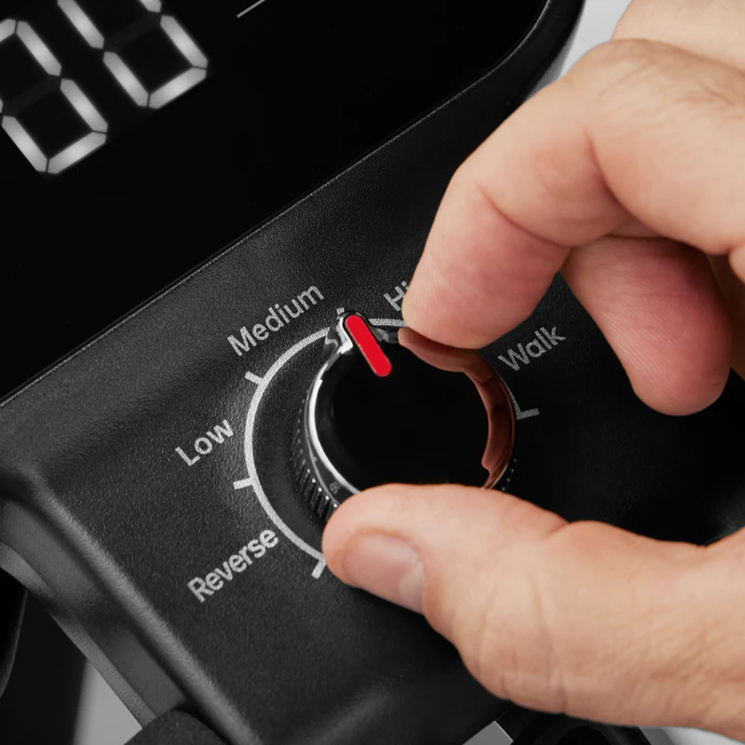 A hand adjusts a black dial with a red indicator on the Paiseec Mobility Scooter Parts control panel, labeled Reverse, Low, Medium, High, and Walk. A digital display with part of a number appears above the dial.