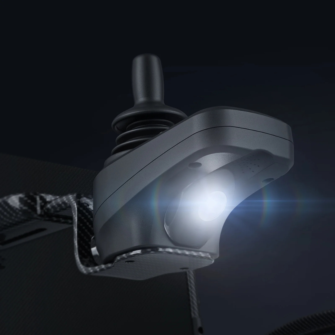 Close-up of the Paiseec Q5 Carbon Fiber Electric Wheelchair's sleek black joystick controller with a glowing LED, mounted on a dark textured surface. Its modern design and bright accents stand out against the background.